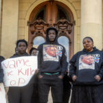 
              The Lyoya family stands together on the steps of the Michigan Capitol to demand justice in the police shooting that took the life of Congolese immigrant Patrick Lyoya, Thursday, April 21, 2022 in Lansing Mich. (Jake May/The Flint Journal via AP)
            