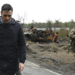 
              In this photo provided by the Spanish government, Spain's Prime Minister Pedro Sanchez walks past a burned military vehicle as he visits the city of Borodyanka, Ukraine, Thursday, April 21, 2022. Spain's Prime Minister Pedro Sanchez said he was "shocked to witness the horror and atrocities of Putin's war on the streets of Borodyanka," a town in northern Ukraine that has been devasted by the invasion. (Spanish Government via AP)
            