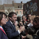
              Current French President and centrist presidential candidate for reelection Emmanuel Macron meets residents as he campaigns in Denain, northern France, Monday, April 11, 2022 . French President Emmanuel Macron may be ahead in the presidential race so far, but he warned his supporters that "nothing is done" and his runoff battle with far-right challenger Marine Le Pen will be a hard fight. At left is local mayor Anne-Lise Dufour-Tonini. (AP Photo/Lewis Joly, Pool)
            