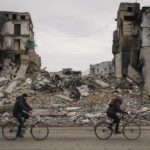 
              People ride bicycles by an apartment building destroyed during fighting between Ukrainian and Russian forces in Borodyanka, Ukraine, Tuesday, April 5, 2022. Ukrainian President Volodymyr Zelenskyy accused Russian troops of gruesome atrocities in Ukraine and told the U.N. Security Council on Tuesday that those responsible should immediately be brought up on war crimes charges in front of a tribunal like the one set up at Nuremberg after World War II.(AP Photo/Vadim Ghirda)
            