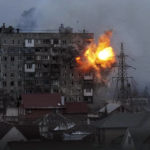 
              FILE - An explosion is seen in an apartment building after Russian's army tank fires in Mariupol, Ukraine, Friday, March 11, 2022. (AP Photo/Evgeniy Maloletka, File)
            