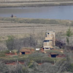 
              A North Korean rides a bicycle past near a North Korean military guard post, bottom, seen from the unification observatory in Paju, South Korea, Friday, April 15, 2022. North Korea is marking a key state anniversary Friday with calls for stronger loyalty to leader Kim Jong Un, but there was no word on an expected military parade to display new weapons amid heightened animosities with the United States. (AP Photo/Lee Jin-man)
            