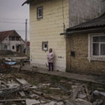 
              A woman watches as workers remove the bodies of three men killed in Bucha, outskirts of Kyiv, Ukraine, Tuesday, April 5, 2022. Ukraine’s president plans to address the U.N.’s most powerful body after even more grisly evidence emerged of civilian massacres in areas that Russian forces recently left. (AP Photo/Felipe Dana)
            