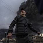 
              A man stands as smoke rises in the air in the background after shelling in Odesa, Ukraine, Sunday, April 3, 2022. (AP Photo/Petros Giannakouris)
            