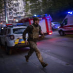 
              A security member runs following an explosion in Kyiv, Ukraine on Thursday, April 28, 2022. Russia struck the Ukrainian capital of Kyiv shortly after a meeting between President Volodymyr Zelenskyy and U.N. Secretary-General António Guterres on Thursday evening. (AP Photo/Emilio Morenatti)
            