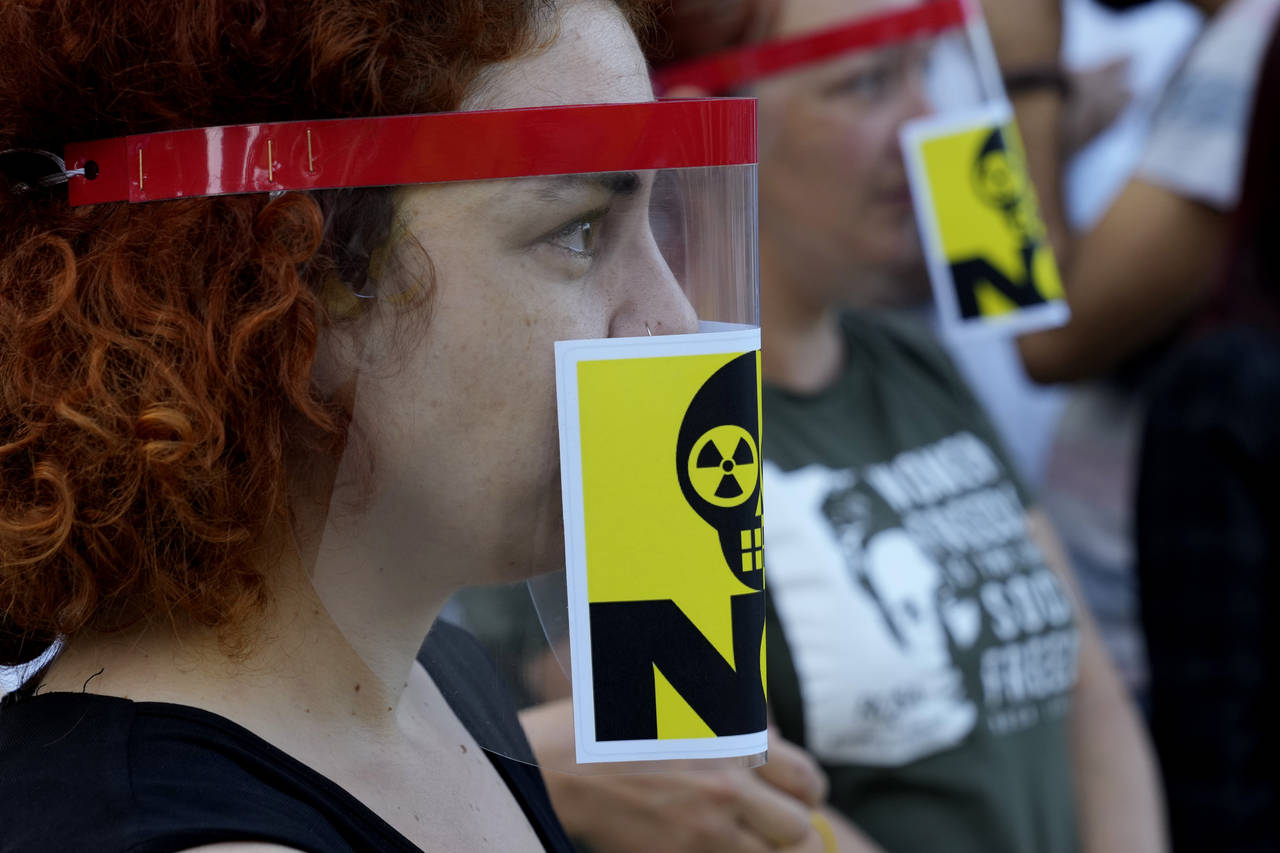 Greek Cypriot and Turkish Cypriot activists with an anti-nuclear stickers on their masks take part ...
