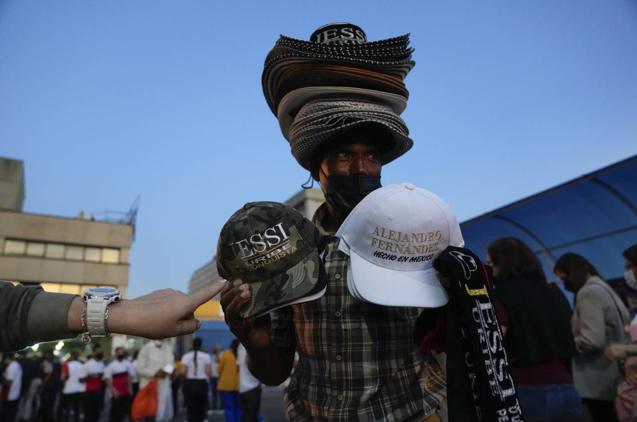 FILE -  A man sells hats with the name of Mexican singer Alejandro Fernandez and Colombian singer J...
