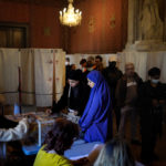 
              Voters casts their ballots for the first round of the presidential election in Marseille, southern France, Sunday, April 10, 2022. Up to 48 million French voters headed to polling stations nationwide Sunday for the first round of the country's presidential election, one that seemed for months like a shoo-in for French President Emmanuel Macron but is now a tossup amid a strong challenge from the far right's Marine Le Pen. (AP Photo/Daniel Cole)
            