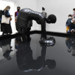 
              People admire "Last Garment" a bronze sculpture by American sculptor Simone Leigh, part of the "Sovereignty" installation during the unveiling of the United States' pavilion at the 59th Biennale of Arts exhibition in Venice, Italy, Thursday, April 21, 2022. Leigh is the first Black woman to headline the U.S. Pavilion. (AP Photo/Luigi Costantini)
            