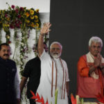 
              India’s Prime Minister Narendra Modi, flanked by Lieutenant Governor of Jammu and Kashmir Manoj Sinha, right and Union Minister Jitendra Singh waves at a function to commemorate the annual Panchayati Raj, or grassroots democracy, Day in Palli village near Jammu, India, Sunday, April 24, 2022. Modi visited Himalayan Kashmir for his first public event on Sunday since New Delhi stripped the disputed region’s semi-autonomy and took direct control in 2019. (AP Photo/Channi Anand)
            