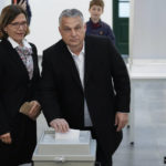 
              Hungary's nationalist prime minister, Viktor Orban, center, and his wife Aniko Levai, left, cast their vote for general election in Budapest, Hungary, Sunday, April 3, 2022. Orban seeks a fourth straight term in office, a coalition of opposition parties are framing the election as a referendum on Hungary's future in the West. (AP Photo/Petr David Josek)
            