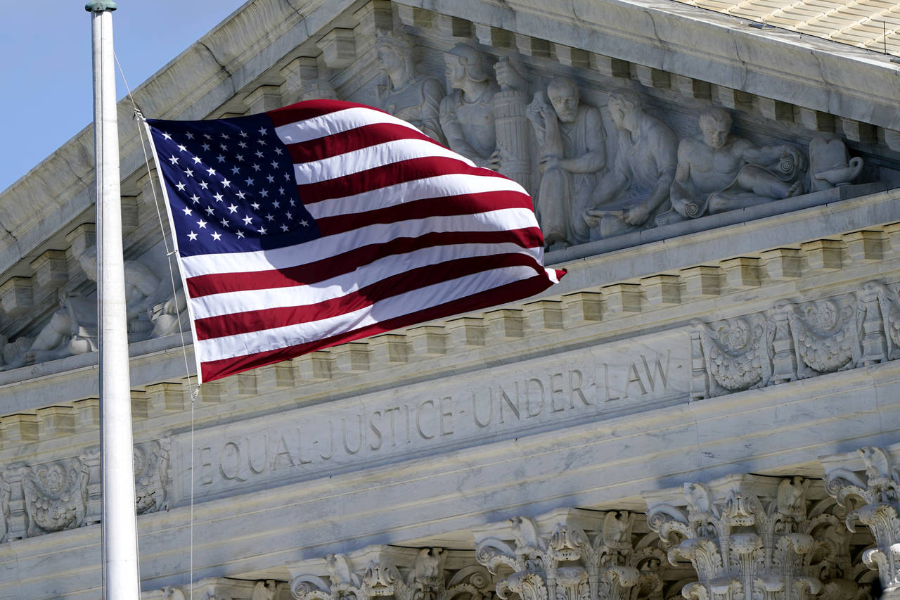 FILE - An American flag waves in front of the Supreme Court building, Nov. 2, 2020, on Capitol Hill...