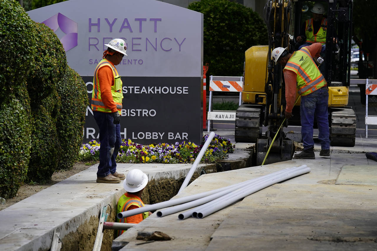 Workers install piping for underground electrical lines in Sacramento, Calif., Wednesday, April 20,...