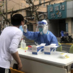 
              A medical worker conducts COVID-19 tests for residents after a confirmed case was found in the community on Sunday, April 10, 2022, in Shanghai. (AP Photo/Chen Si)
            