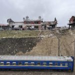 
              A train travelling from Dnipro passes by the area where emergency workers clear up debris after an airstrike hit a tire shop in the western city of Lviv, Ukraine, Monday April 18, 2022. Russian missiles hit the city of Lviv in western Ukraine on Monday, killing at least six people, Ukrainian officials said, as Moscow’s troops stepped up strikes on infrastructure in preparation for an all-out assault on the east. (AP Photo/Philip Crowther)
            