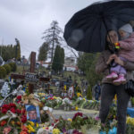 
              Tetiana Rurak, 25-year-old widow Oleksandra Rurak, visits her soldier husband Volodymyr Rurak's, grave with her one and a half year old daughter, after he was killed in action, at the Lychakiv cemetery, in Lviv, western Ukraine, Tuesday, April 5, 2022. (AP Photo/Nariman El-Mofty)
            