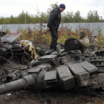 
              A Ukrainian soldier examines a destroyed Russian tank in the village of Dmytrivka close to Kyiv, Ukraine, Saturday, April 2, 2022. At least ten Russian tanks were destroyed in the fighting two days ago in Dmytrivka. (AP Photo/Efrem Lukatsky)
            
