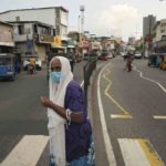 
              A Sri Lankan woman crosses a street, before the beginning of curfew in Colombo, Sri Lanka, Saturday, April 2, 2022. Sri Lanka imposed a countrywide curfew starting Saturday evening until Monday morning, in addition to a state of emergency declared by the president, in an attempt to prevent more unrest after protesters took to the streets blaming the government for the worsening economic crisis.  (AP Photo/Eranga Jayawardena)
            