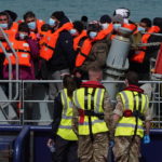 
              A group of people thought to be migrants are brought in to Dover, Kent, England, by the RNLI, following a small boat incident in the Channel, Thursday April 14, 2022. Britain's Conservative government has struck a deal with Rwanda to send some asylum-seekers thousands of miles away to the East African country. Opposition politicians and refugee groups are condemning the plan as unworkable, inhumane and a waste of public money. (Gareth Fuller/PA via AP)
            