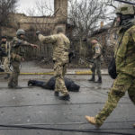 
              Ukrainian servicemen attach a cable to the body of a civilian while checking for booby traps in the formerly Russian-occupied Kyiv suburb of Bucha, Ukraine, Saturday, April 2, 2022. As Russian forces pull back from Ukraine's capital region, retreating troops are creating a "catastrophic" situation for civilians by leaving mines around homes, abandoned equipment and "even the bodies of those killed," President Volodymyr Zelenskyy warned Saturday.(AP Photo/Vadim Ghirda)
            