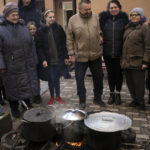 
              People gather around a soup kitchen in Bucha, on the outskirts of Kyiv, Ukraine, Monday, April 4, 2022. Russia is facing a fresh wave of condemnation after evidence emerged of what appeared to be deliberate killings of dozens if not hundreds of civilians in Ukraine. (AP Photo/Rodrigo Abd)
            