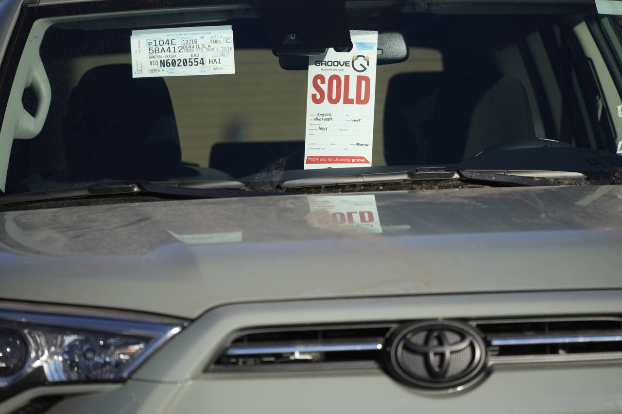 FILE - A sold tag hangs from the inside rear-view mirror of a 2022 4Runner sports-utility vehicle a...
