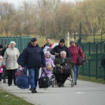 
              Refugees walk after fleeing the war from neighbouring Ukraine at the border crossing in Medyka, southeastern Poland, Monday, April 11, 2022. (AP Photo/Sergei Grits)
            