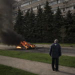 
              A man watches as a car burns with two people inside, after a Russian bombardment in Kharkiv, Ukraine, Thursday, April 21, 2022. (AP Photo/Felipe Dana)
            