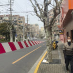 
              A resident walks past barriers along the locked down Jingan district of western Shanghai, China, Friday, April 1, 2022. As residents of western Shanghai start a four day lockdown for mass testing, some in eastern Shanghai about to end their lock down are being told they will be confined to their homes for at least 10 more days. It was the latest wrinkle in the lockdown of China's largest city as it struggles to eliminate an omicron-driven coronavirus outbreak under China's zero-COVID policy. (AP Photo/Chen Si)
            