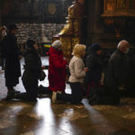 
              Worshippers wait in line on their knees during Easter Orthodox Christian celebrations at the Saints Peter and Garrison church in Lviv, western Ukraine, Friday, April 22, 2022. New satellite images show apparent mass graves near Mariupol, where local officials accused Russia of burying up to 9,000 Ukrainian civilians to conceal the slaughter taking place in the ruined port city that's almost entirely under Russian control. (AP Photo/Francisco Seco)
            