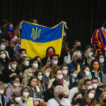 
              People show an Ukrainian national flag during Pope Francis' weekly general audience in the Paul VI Hall, at the Vatican, Wednesday, April 6, 2022. (AP Photo/Alessandra Tarantino)
            