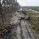 
              FILE - Ukrainian soldiers stand amid destroyed Russian armor vehicles in the outskirts of Kyiv, Ukraine March 31, 2022. Russian forces shelled Kyiv suburbs, two days after the Kremlin announced it would significantly scale back operations near both the capital and the northern city of Chernihiv to increase trust between the two sides. (AP Photo/Rodrigo Abd, File)
            