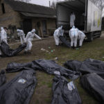 
              Volunteers load bodies of civilians killed in Bucha onto a truck to be taken to a morgue for investigation, in the outskirts of Kyiv, Ukraine, Tuesday, April 12, 2022. (AP Photo/Rodrigo Abd)
            