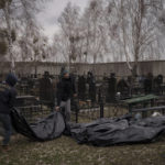 
              Workers carry the body of people found dead to a cemetery in Bucha, outskirts of Kyiv, Ukraine, Tuesday, April 5, 2022. Ukraine’s president told the U.N. Security Council on Tuesday that the Russian military must be brought to justice immediately for war crimes, accusing invading troops of the worst atrocities since World War II. He stressed that Bucha was only one place and there are more with similar horrors. (AP Photo/Felipe Dana)
            