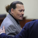
              Actor Johnny Depp speaks to his attorney during a hearing in the courtroom at the Fairfax County Circuit Court in Fairfax, Va., Wednesday, April 20, 2022. Actor Johnny Depp sued his ex-wife Amber Heard for libel in Fairfax County Circuit Court after she wrote an op-ed piece in The Washington Post in 2018 referring to herself as a "public figure representing domestic abuse." (Evelyn Hockstein/Pool via AP)
            