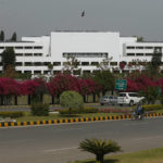 
              A motorcyclist rides past the National Assembly where the session to choose the new prime minister continues in Islamabad, Pakistan, Monday, April 11, 2022. Pakistani lawmakers are to choose a new prime minister on Monday, capping a tumultuous week of political drama that saw the ouster of Imran Khan as premier and a constitutional crisis narrowly averted after the country's top court stepped in. (AP Photo/Anjum Naveed)
            