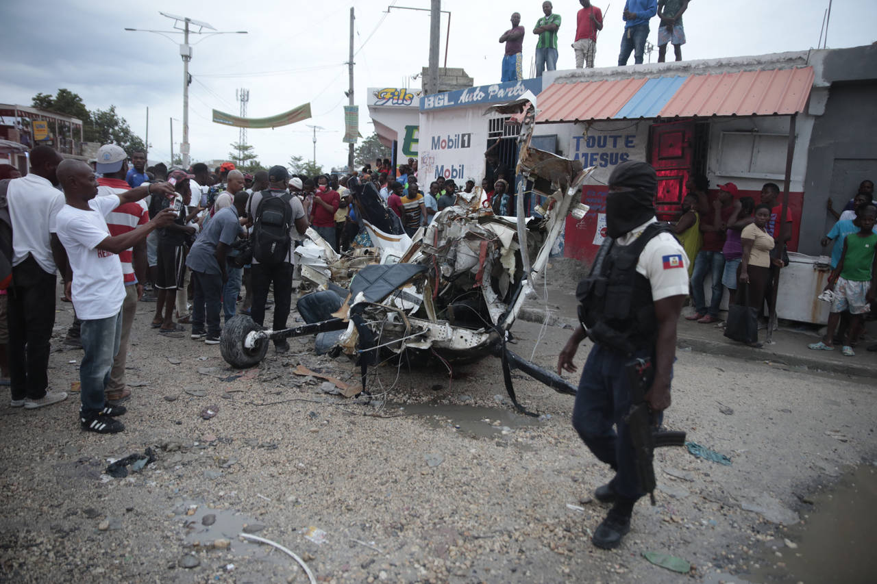 Police guard the crash site of a small plane in the community of Carrefour, Port-au-Prince, Haiti, ...