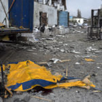 
              The body of a man is covered by a tarp from a damaged truck following a Russian bombing of a factory in Kramatorsk, in eastern Ukraine, on Tuesday, April 19, 2022. Russian forces attacked along a broad front in eastern Ukraine on Tuesday as part of a full-scale ground offensive to take control of the country's eastern industrial heartland in what Ukrainian officials called a "new phase of the war." (AP Photo/Petros Giannakouris)
            