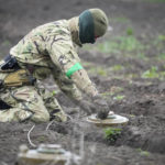 
              An interior ministry sapper defuses a mine on a mine field after recent battles in Irpin close to Kyiv, Ukraine, Tuesday, April 19, 2022. (AP Photo/Efrem Lukatsky)
            