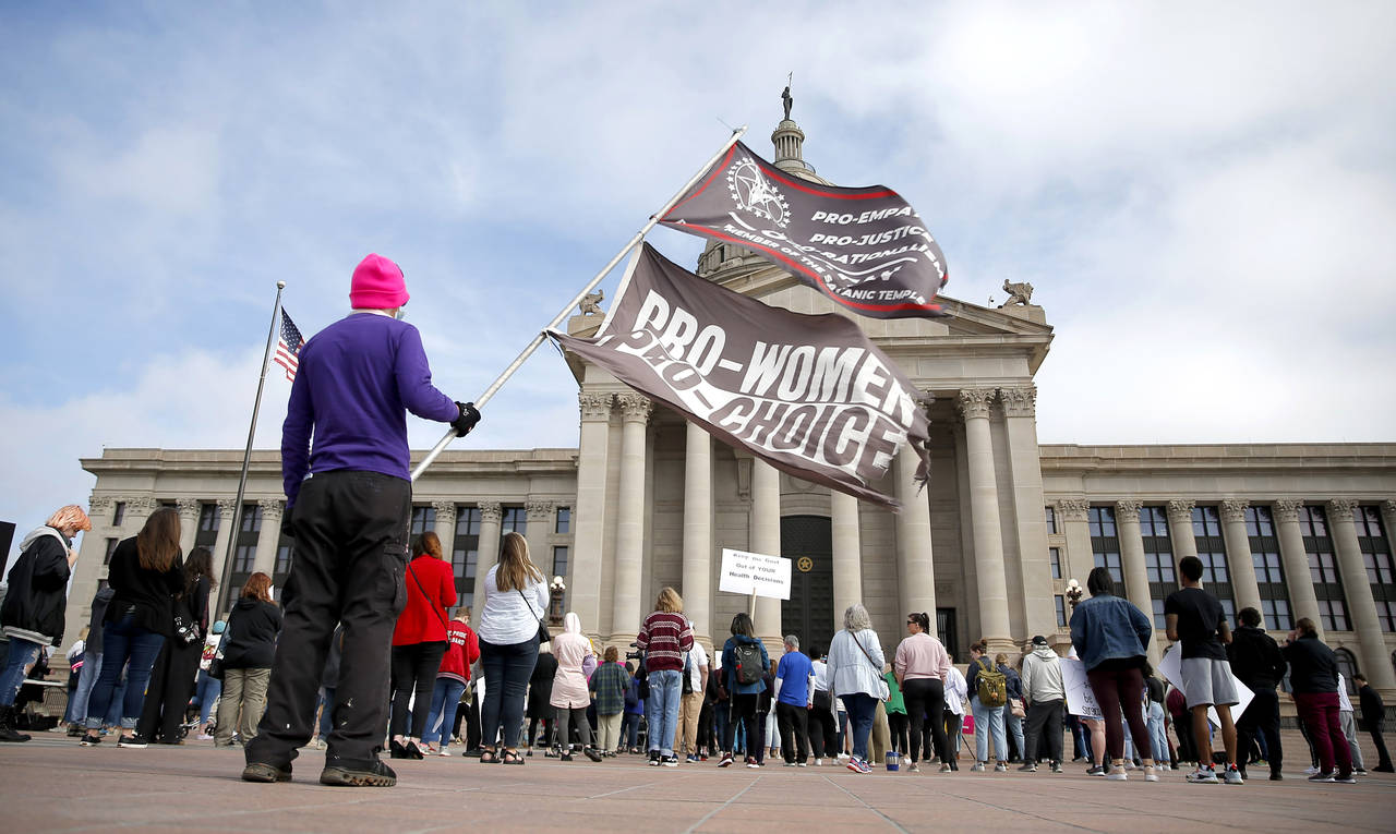 FILE - A person holds flags during the Bans Off Oklahoma Rally on the steps on Oklahoma state Capit...