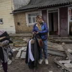 
              Relatives of three men killed in the courtyard of a house, remove clothing and valuables from the home in Bucha, in the outskirts of Kyiv, Ukraine, Tuesday, April 5, 2022. (AP Photo/Rodrigo Abd)
            
