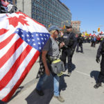 
              A protester walks past police at a demonstration, part of a convoy-style protest participants are calling "Rolling Thunder" in Ottawa, Ontario, on Saturday, April 30, 2022. (Patrick Doyle/The Canadian Press via AP)
            