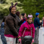 
              People walk on the South Lawn of the White House in Washington, Monday, April 18, 2022, during the White House Easter Egg Roll. (AP Photo/Andrew Harnik)
            