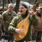 
              Taras Kompanichenko, a well-known Ukrainian artist and a volunteer of the Territorial Defense Forces, plays kobza, a folk string instrument, on Easter eve at a military position outside Kyiv, Ukraine, Saturday, Apr. 23, 2022. (AP Photo/Efrem Lukatsky)
            