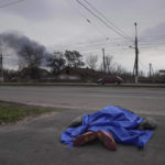 
              FILE - A body lies covered by a tarp in the street in Mariupol, Ukraine, Monday, March 7, 2022. (AP Photo/Evgeniy Maloletka, File)
            