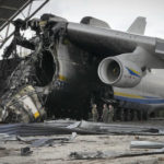 
              Ukrainian soldiers stand at the remains of the Antonov An-225 world's biggest cargo aircraft surrounded by Russian military vehicles destroyed during recent fighting between Russian and Ukrainian forces are seen at the Antonov airport in Hostomel, outskirts of Kyiv, Ukraine, Monday, April 18, 2022. (AP Photo/Efrem Lukatsky)
            