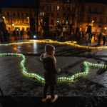 
              A girl stands in front of lit candles forming the shape of Ukraine's map, in memory of lost lives, in front of the Taras Shevchenko monument, in Lviv, western Ukraine, late Tuesday, April 5, 2022. (AP Photo/Nariman El-Mofty)
            