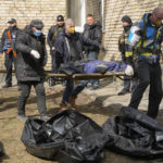 
              Volunteers collect bodies of murdered civilians, in Bucha, close to Kyiv, Ukraine, Monday, April 4, 2022. Russia is facing a fresh wave of condemnation after evidence emerged of what appeared to be deliberate killings of civilians in Ukraine. (AP Photo/Efrem Lukatsky)
            