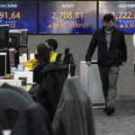 
              Currency traders walk by screens showing the Korea Composite Stock Price Index (KOSPI) and the foreign exchange rate between U.S. dollar and South Korean won, right, at the foreign exchange dealing room of the KEB Hana Bank headquarters in Seoul, South Korea, Friday, April 8, 2022. Asian shares were mostly lower Friday as investors eyed the war in Ukraine and what the world's central banks might do to keep inflation in check. (AP Photo/Ahn Young-joon)
            