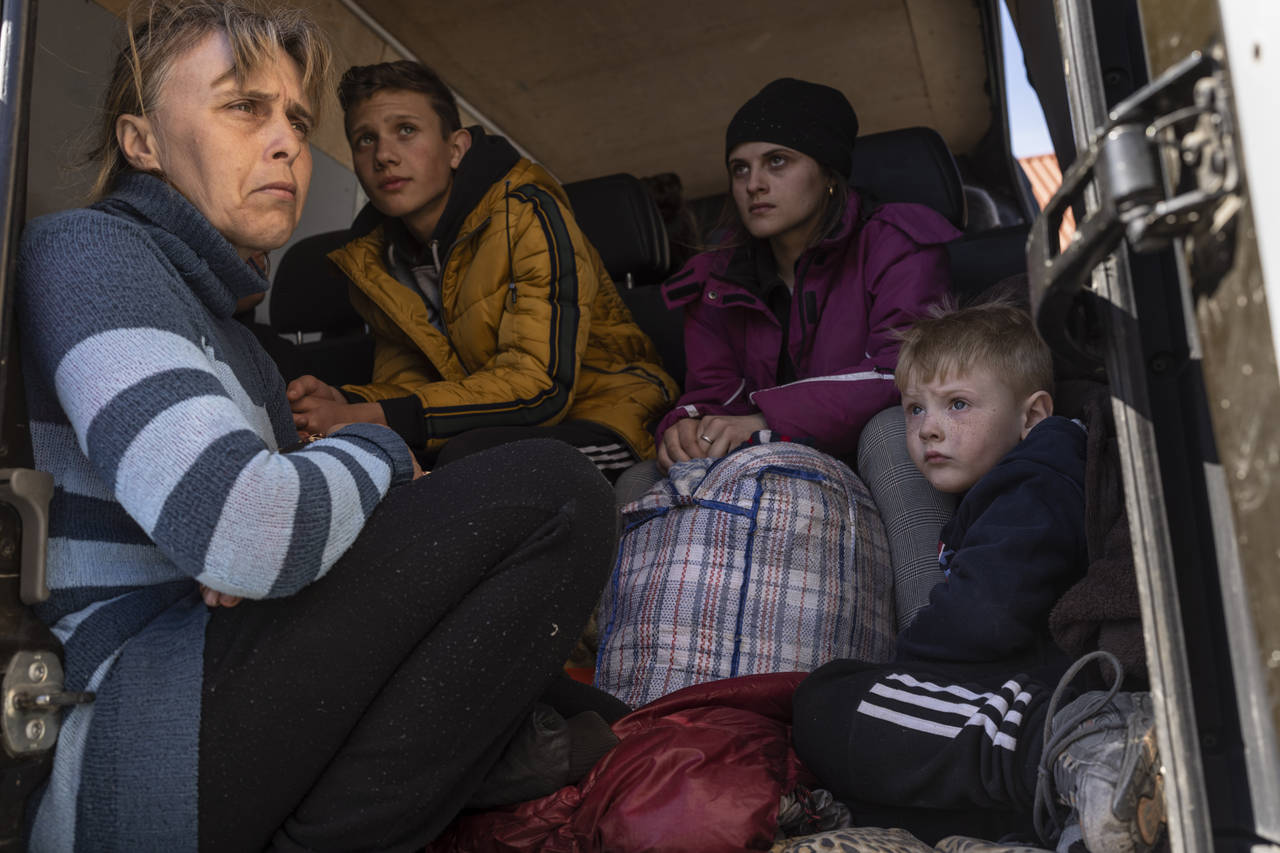 Oksana Gavrielutca 41, from left, sits at the back of a bus with her children Oleg 18, Diana, 17, a...